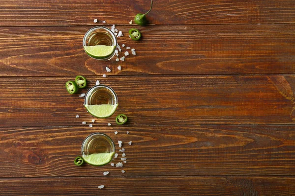 Shots of tequila on wooden table — Stock Photo, Image