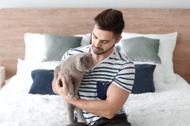 Evde sevimli komik kedi ile genç adam