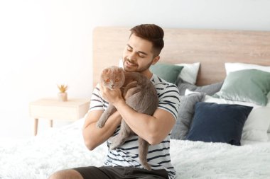 Evde sevimli komik kedi ile genç adam