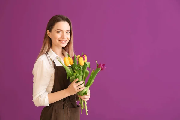 Jovem florista feminina com buquê sobre fundo de cor — Fotografia de Stock