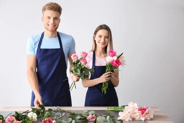 Florists az asztalnál a fény háttere ellen — Stock Fotó