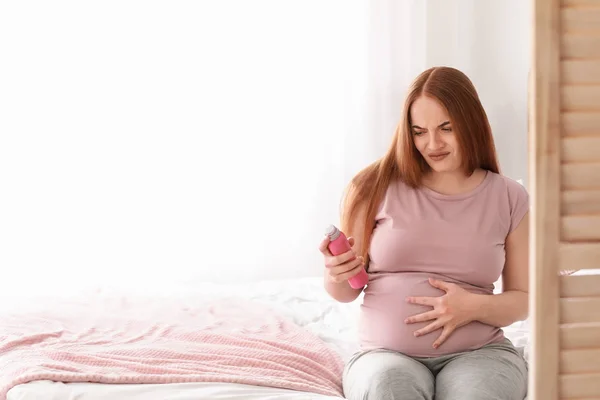 Young pregnant woman with antiperspirant suffering from toxicosis at home — Stock Photo, Image