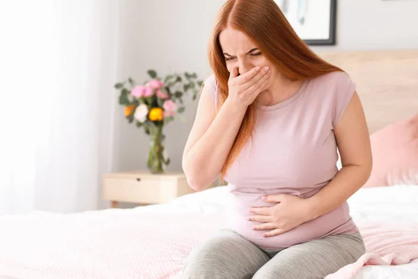 Mujer embarazada joven que sufre de toxicosis en casa — Foto de Stock