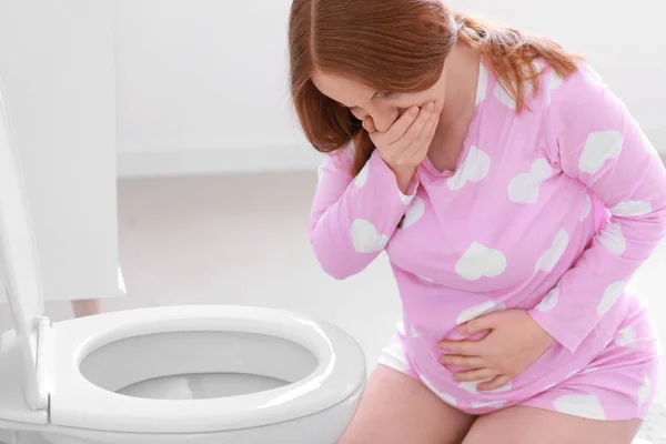 Young pregnant woman suffering from toxicosis in restroom — 스톡 사진