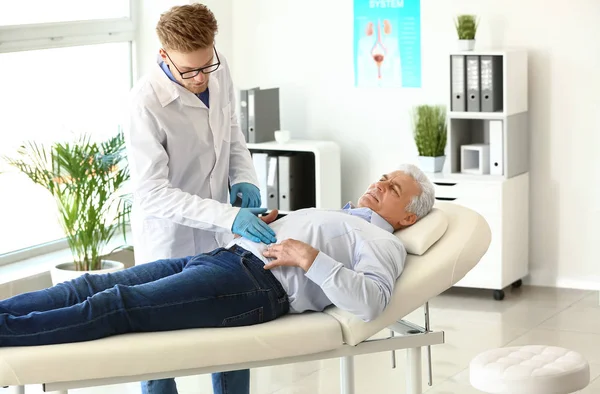 Urologist examining male patient in clinic — Stock Photo, Image