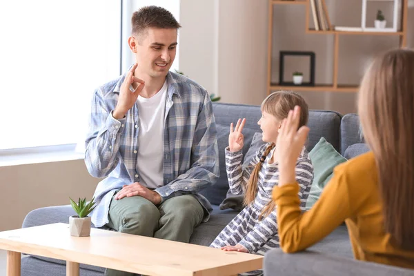 Familia muda sorda usando lenguaje de señas en casa —  Fotos de Stock