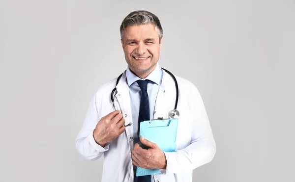 Красивий зрілий лікар на сірому фоні — стокове фото