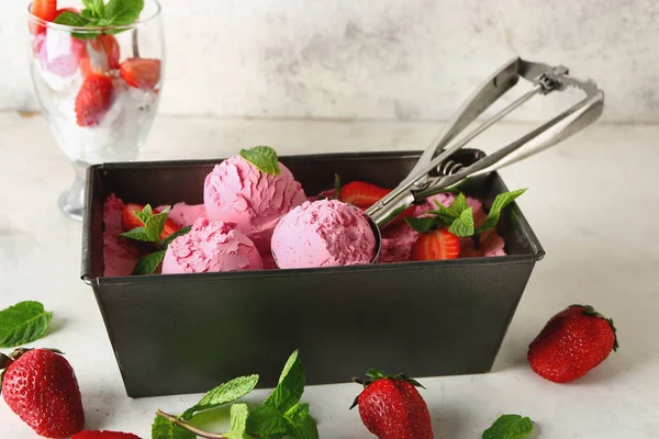 Box with tasty strawberry ice cream on table