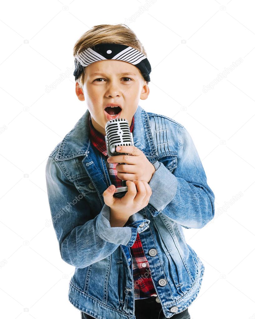 Cute little boy with microphone singing against white background