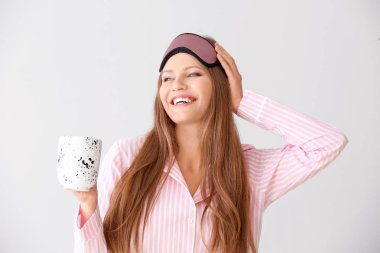 Pijama güzel genç kadın ve hafif arka plan kahve fincan ıstabiri ile