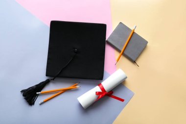 Renkli arka plan üzerinde diploma ve kırtasiye ile Harç kurulu. Lise mezuniyet kavramı