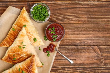 Ahşap masada soslu lezzetli samosas