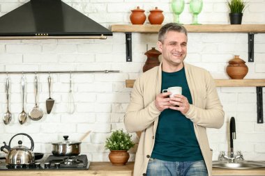 Yakışıklı olgun adam evde mutfakta kahve içme