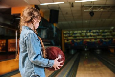Kulüpte bowling oynayan küçük kız.