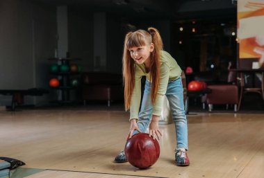 Kulüpte bowling oynayan küçük kız.