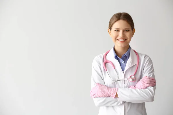 Portrait of young gynecologist on light background — Stock Photo, Image