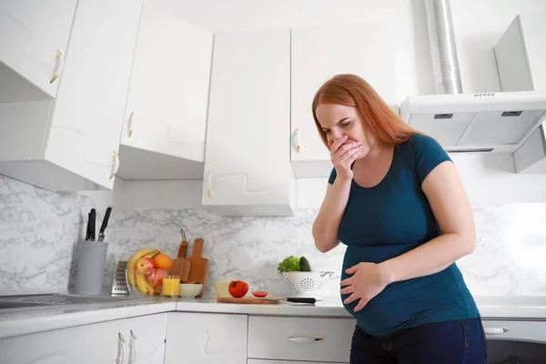 Jovem grávida que sofre de toxicose na cozinha — Fotografia de Stock