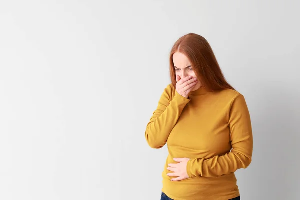 Young pregnant woman suffering from toxicosis on light background — 스톡 사진