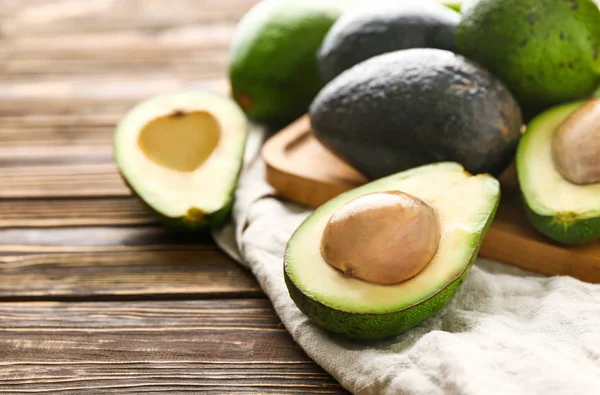 Bord met verse avocado op houten achtergrond — Stockfoto