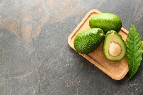 Board with fresh avocado on grey background — Stock Photo, Image
