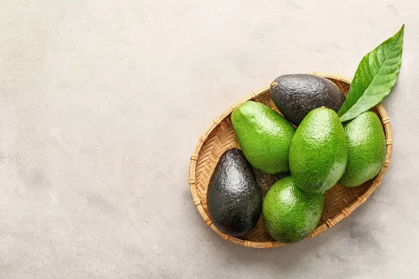 Wicker plate with fresh avocado on grey background — Stock Photo, Image