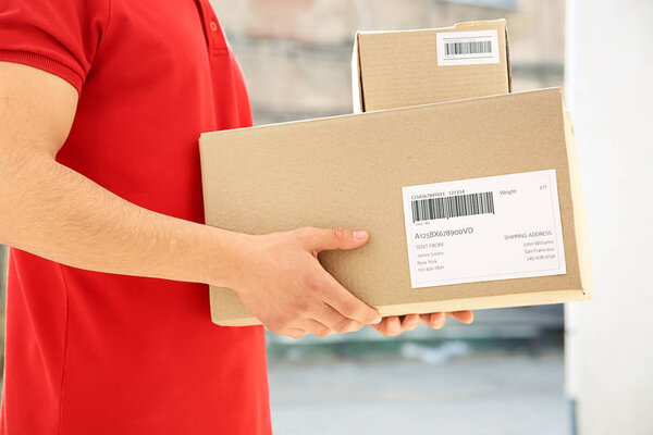 Доставщик с коробками на улице
