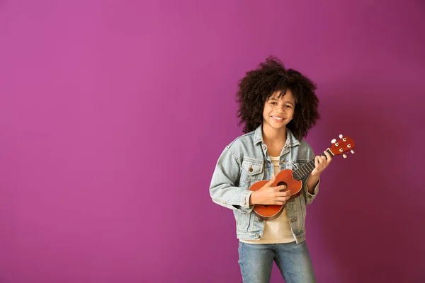 Afrikanisch-amerikanisches Mädchen mit Gitarre vor farbigem Hintergrund — Stockfoto