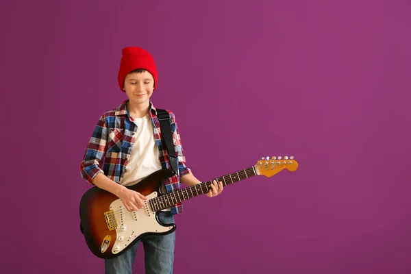 Хлопчик-підліток грає на гітарі на кольоровому фоні — стокове фото