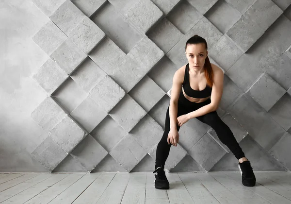 Sportliche Frau gegen graue Wand — Stockfoto