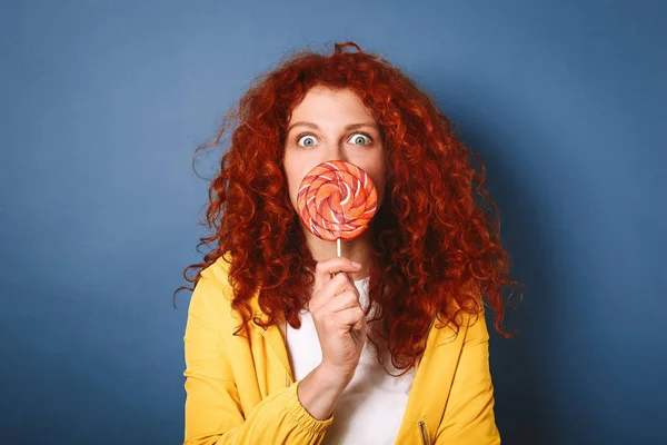 Funny redhead woman with lollipop on color background — Stock Photo, Image