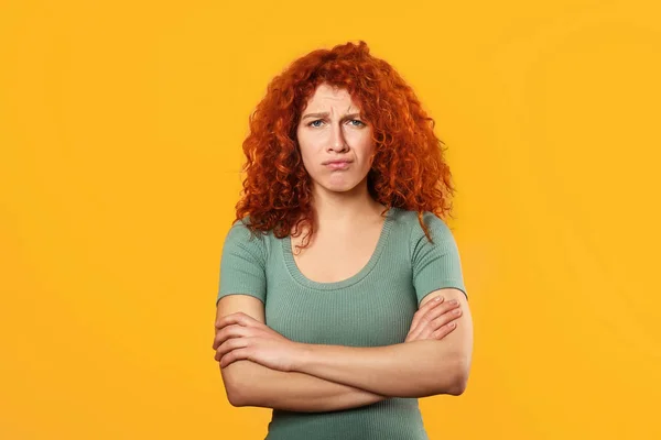 Upset redhead woman on color background — Stock Photo, Image