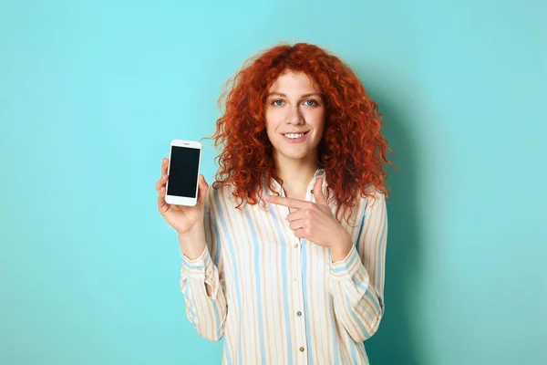 Krásná zrrečanka s mobilním telefonem na barevném pozadí — Stock fotografie