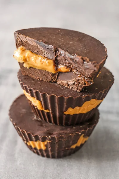 Tasty chocolate peanut butter cups on grey table