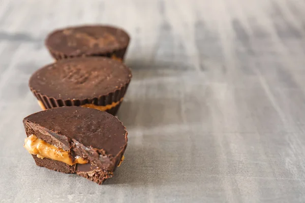 Tasty chocolate peanut butter cups on grey table