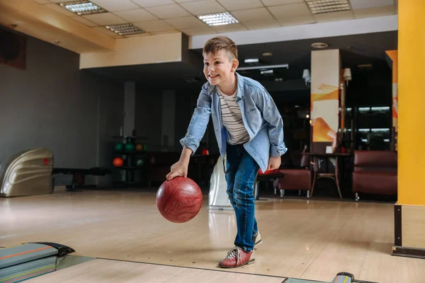 Little boy playing bowling in club — Stock Photo, Image