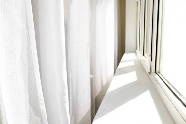 Odada pencere yakınında ışık perdeleri