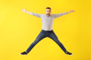 Renkli arka planda zıplayan genç adam