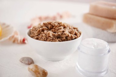 Masanın üzerinde vücut scrub ve krem ile Bowl