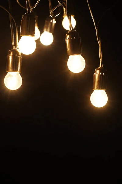 Glowing light bulbs on dark background — Stock Photo, Image