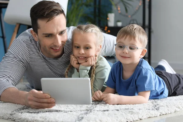 Junger Vater mit kleinen Kindern schaut Cartoons zu Hause — Stockfoto