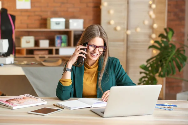 Beautiful female business owner working in atelier — Stock Photo, Image