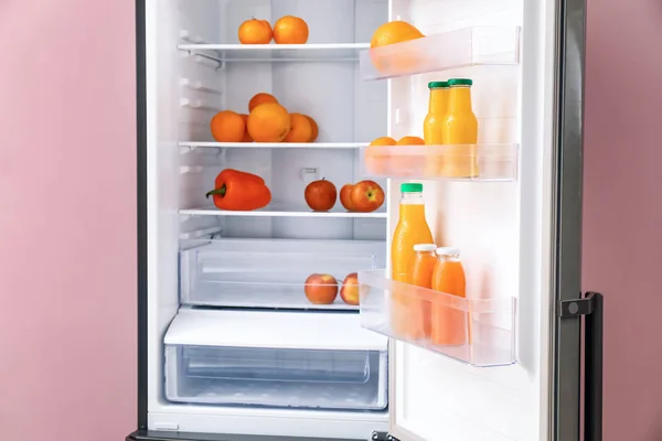 Modern fridge with fresh products on color background, closeup — Stock Photo, Image