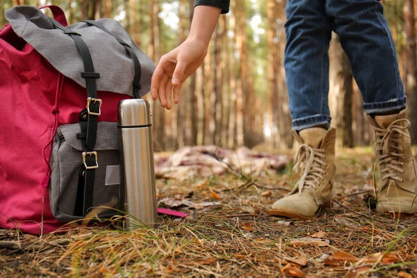 Mujer con mochila y termo viajando por el bosque — Foto de Stock