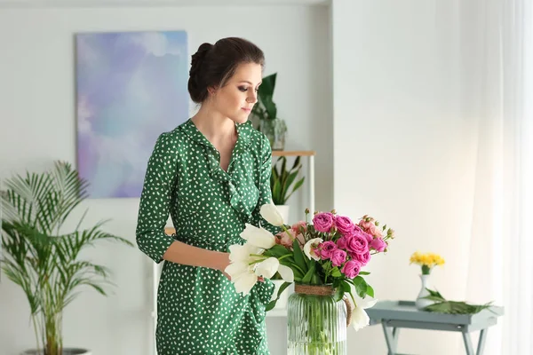 Giovane donna con mazzo di fiori al chiuso — Foto Stock