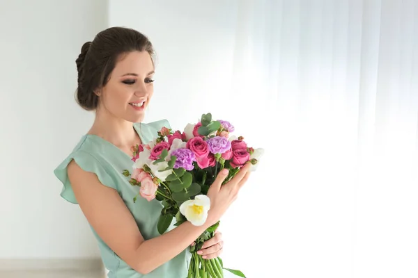 Vacker ung kvinna med bukett blommor hemma — Stockfoto