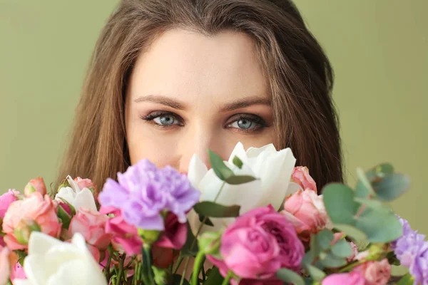 色の背景上の花の花束と美しい若い女性 — ストック写真