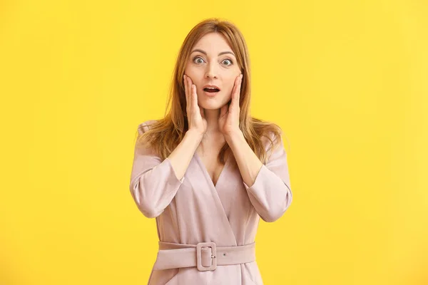 Portret van verrast volwassen vrouw op kleur achtergrond — Stockfoto