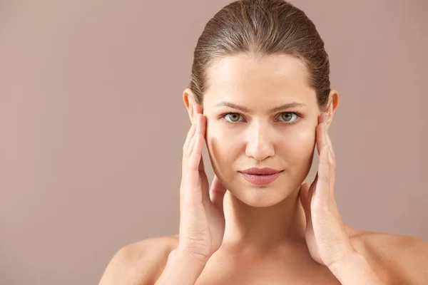 Mooie jonge vrouw op kleur achtergrond — Stockfoto