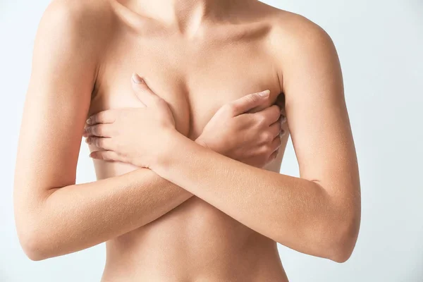 Naked woman on light background. Concept of breast augmentation — Stock Photo, Image