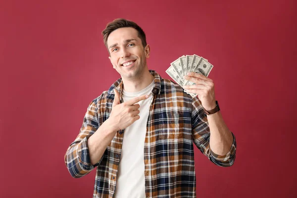 Joven feliz con billetes de dólar sobre fondo de color — Foto de Stock